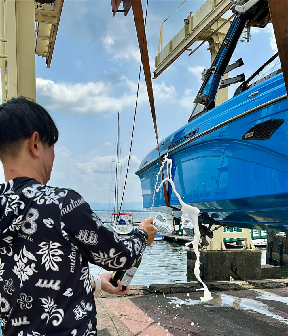 CENTURION BOAT Ri237 2020modelの船体にシャンパンをかける男性