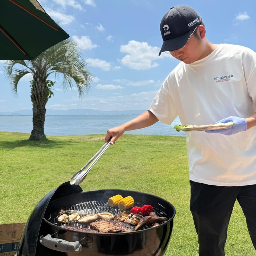 バーベキューで肉を焼く男性